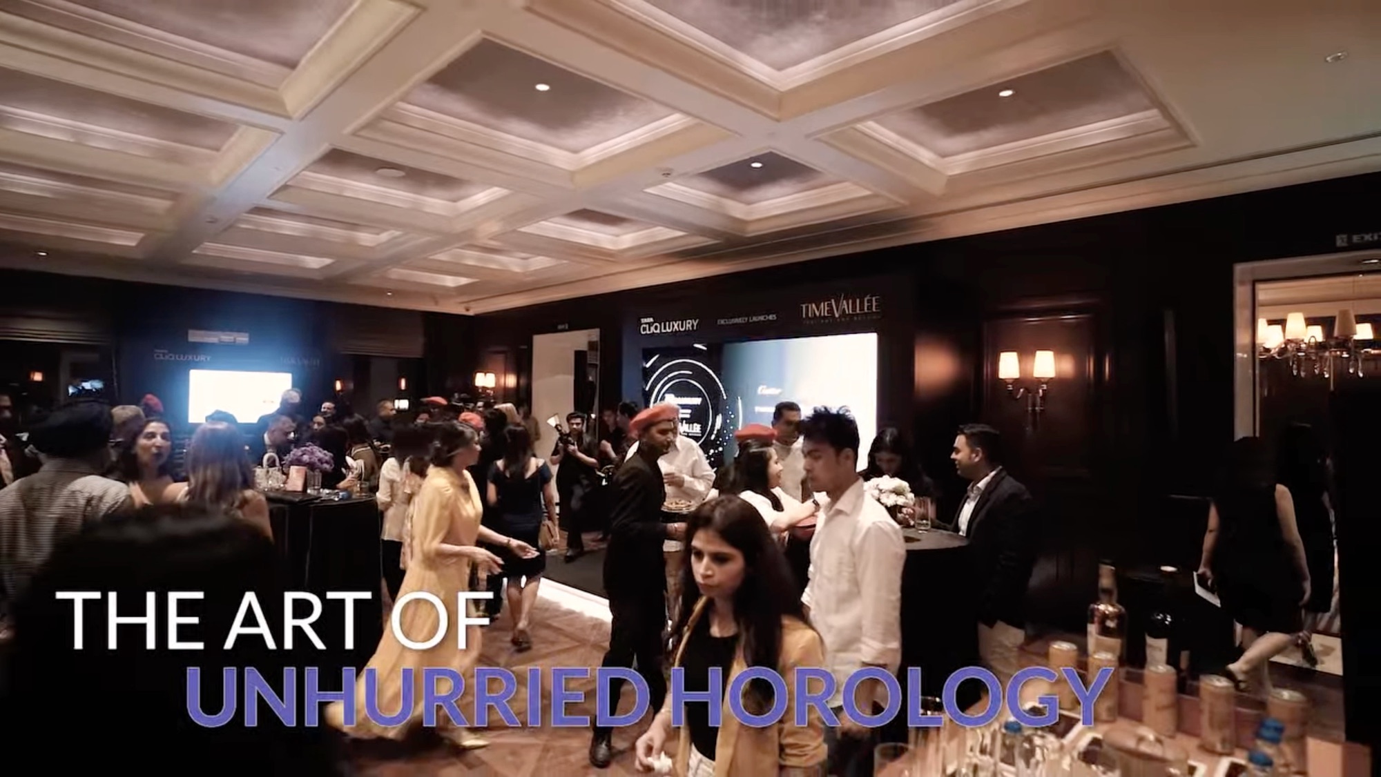 A TimeVallée watch evening: guests mingling in a hotel ballroom, with the line 'The art of unhurried horology'.